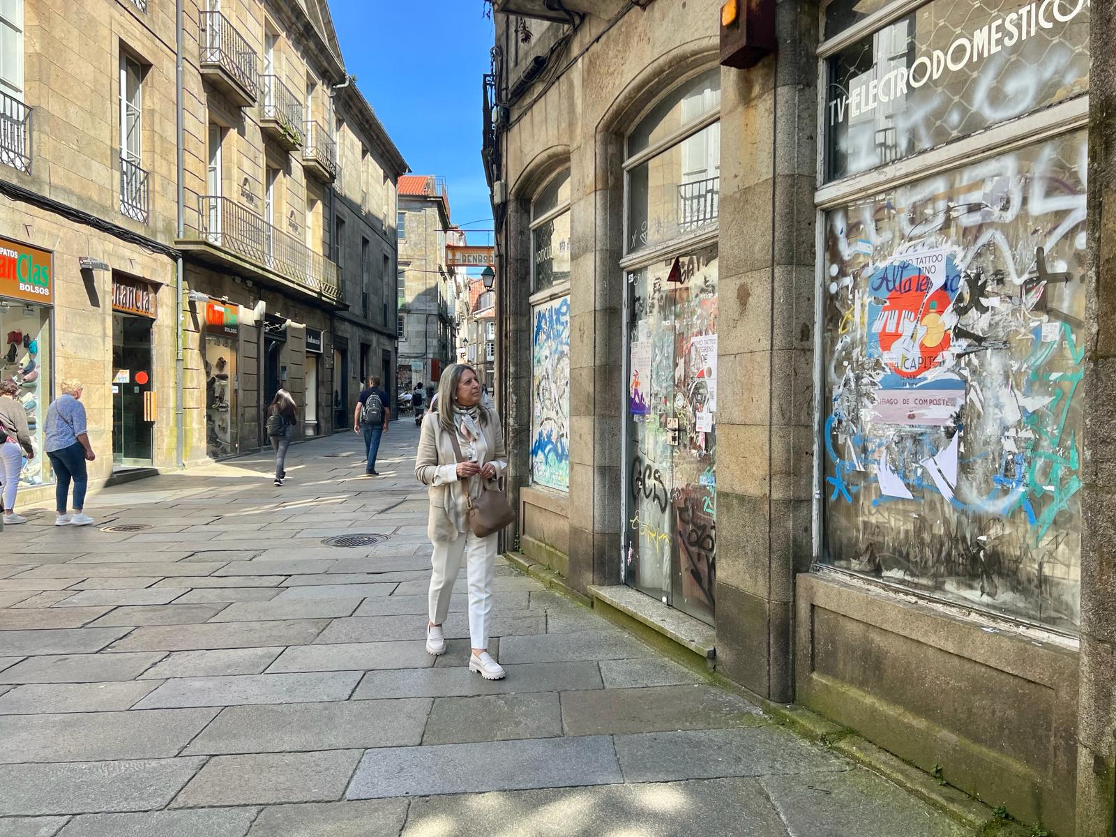 IMAXE – Mila Castro fronte a un dos escaparates bandalizados na rúa do Preguntoiro