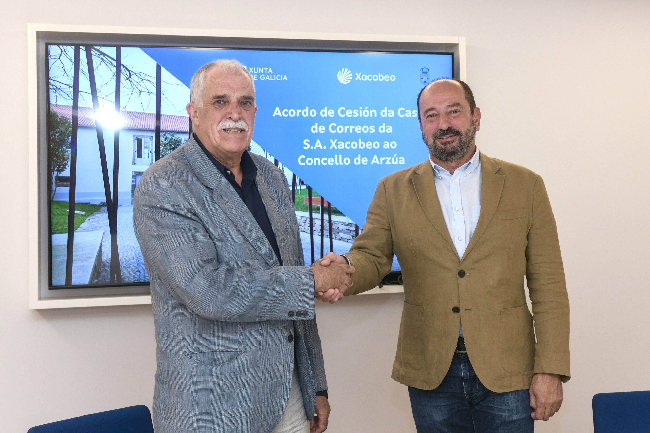 O director de Turismo de Galicia, Xosé Merelles, e o alcalde de Arzúa, Xoán Xesús Carril, asinan o contrato de cesión de uso da Casa de Correos e da Horta Anexa