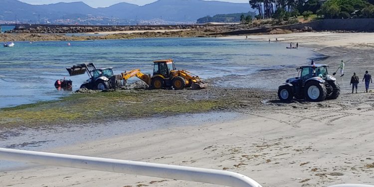 Carrusel de tractores en la playa de Canido, en Vigo, para rescatar a un «chimpín» hundido